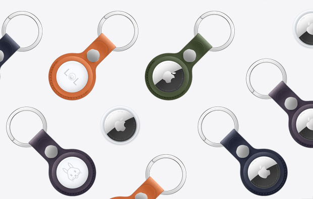多個 AirTag 和配搭不同顏色精細織料鑰匙圈的 AirTag，包括橙色、深綠色、深墨藍色、黑莓色和黑色