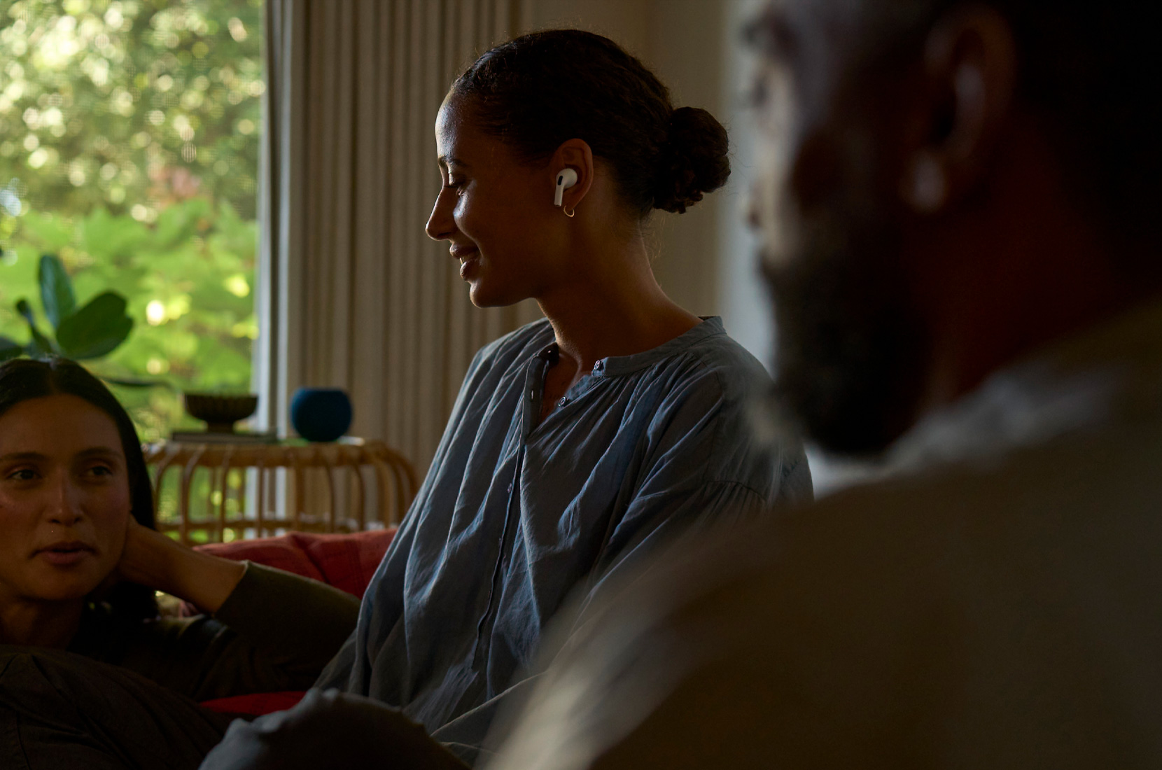 Foto de perfil de una mujer que lleva unos AirPods Pro 2 en la oreja izquierda mientras usa las prestaciones de salud auditiva