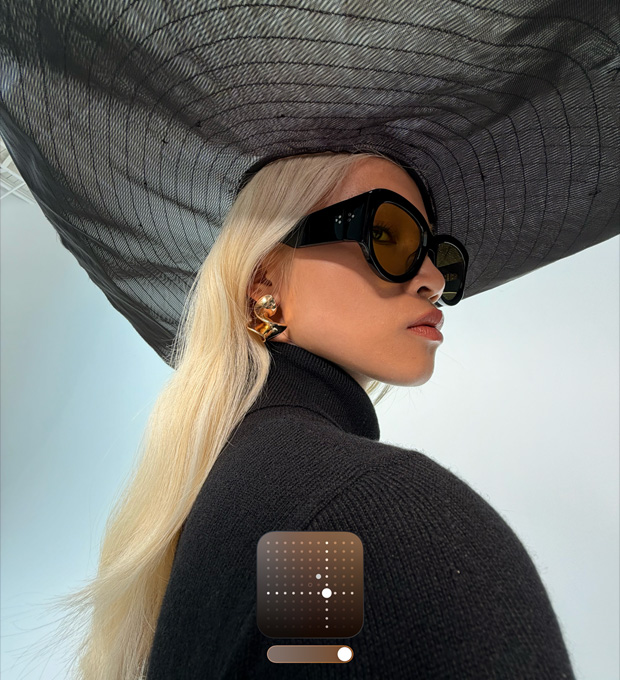 Retrato de mulher com chapéu de abas largas, para ilustrar o Estilo fotográfico Brilhante, que aumenta a luminosidade das fotografias captadas em condições de pouca luz ou no modo Noite