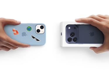 Mano que sujeta un iPhone 13 con una funda de silicona con pegatinas en la parte trasera, al lado de una mano que sujeta la caja de un nuevo iPhone 17