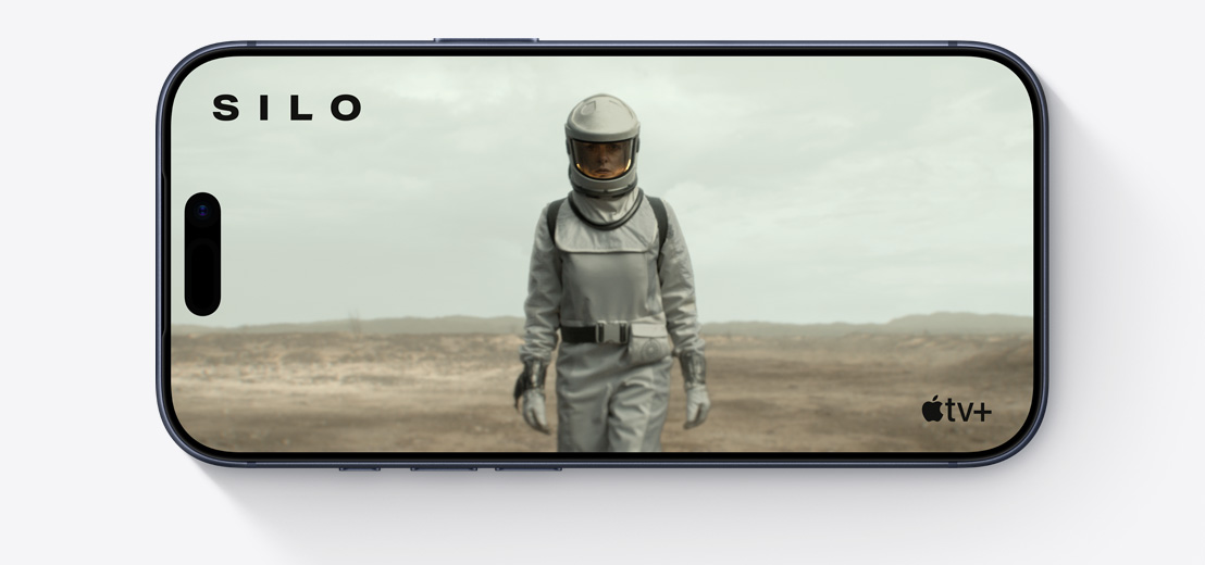 Parte frontal de un iPhone, en horizontal, clip de Apple TV con una persona en traje espacial, Silo