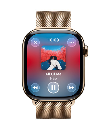Apple Watch em titânio dourado com bracelete Loop milanesa, o mostrador mostra a Apple Music em reprodução, controlos Liquid Glass transparentes